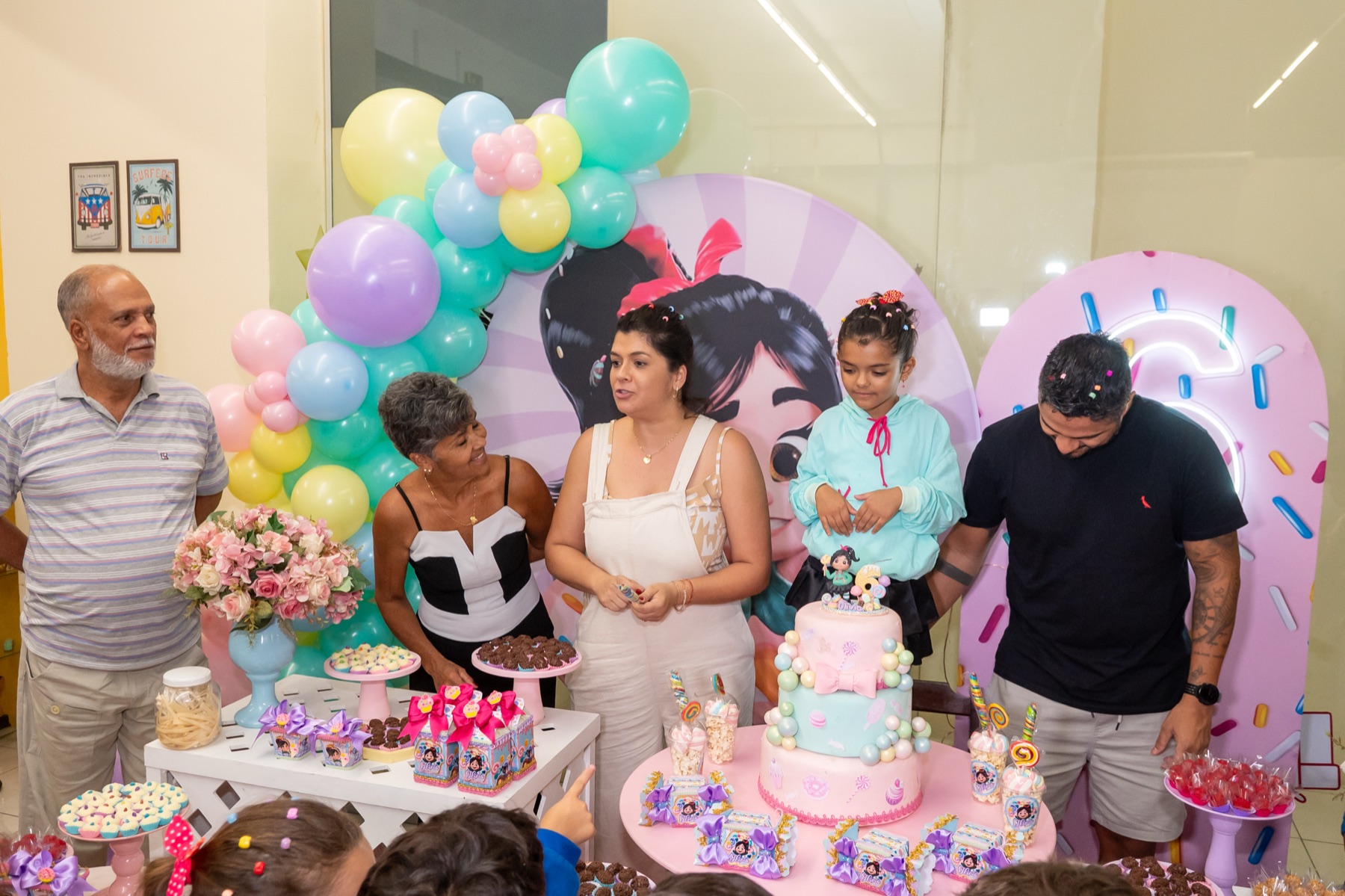 Família reunida cantando parabéns com bolo na área de festa do eKarts